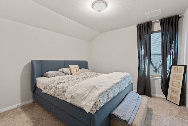 carpeted bedroom featuring a textured ceiling and lofted ceiling