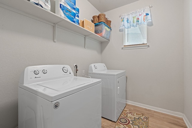 clothes washing area featuring light wood-type flooring and independent washer and dryer