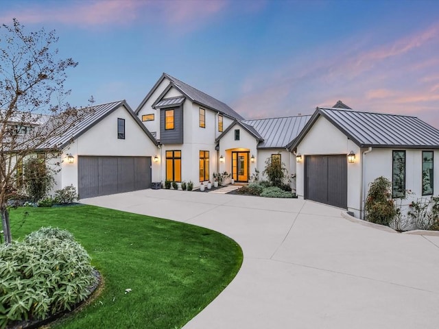 modern inspired farmhouse with a garage and a yard