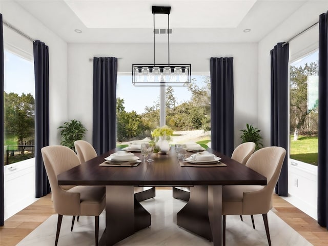 dining space with a notable chandelier and light hardwood / wood-style flooring