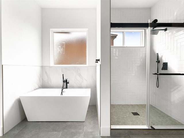 bathroom with tile patterned floors, tile walls, and independent shower and bath