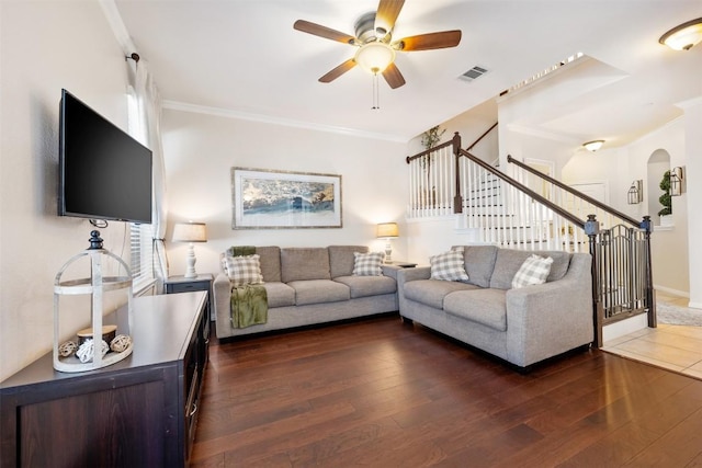 living room with ornamental molding, ceiling fan, and dark wood-type flooring