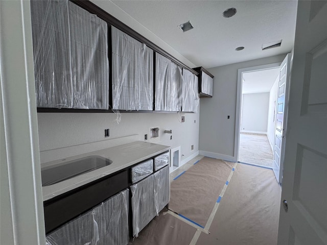 laundry area featuring sink, washer hookup, electric dryer hookup, and cabinets