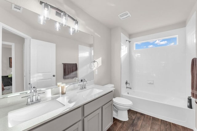 full bathroom with hardwood / wood-style flooring, vanity, toilet, and tub / shower combination