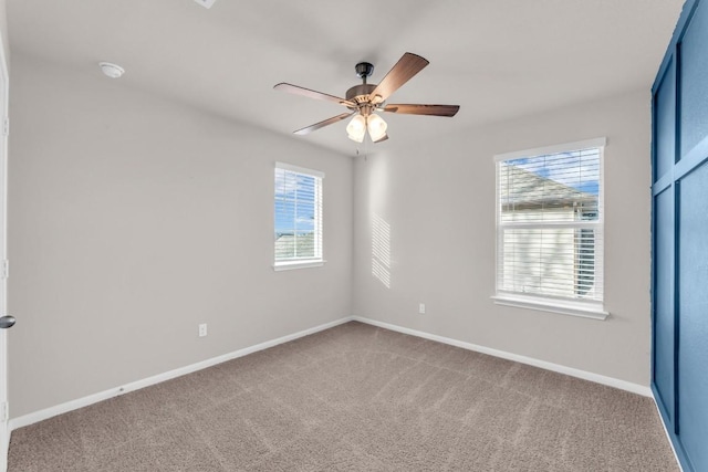 carpeted spare room featuring ceiling fan