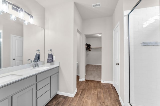 bathroom featuring toilet, vanity, a shower with shower door, and hardwood / wood-style flooring