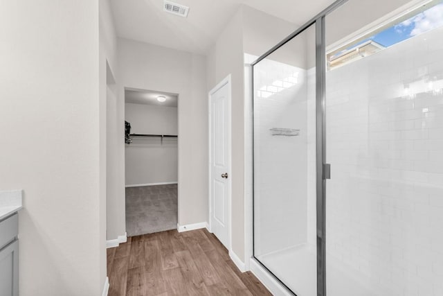 bathroom with hardwood / wood-style flooring, vanity, and a shower with shower door