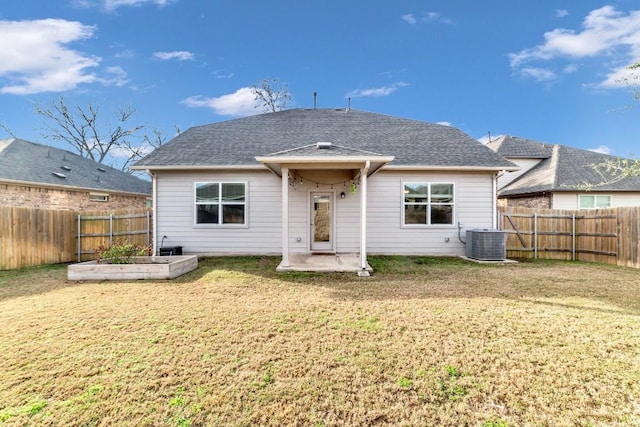 rear view of house featuring a lawn and central air condition unit