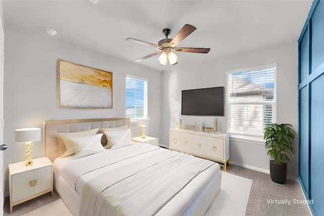 bedroom featuring multiple windows, ceiling fan, and light carpet