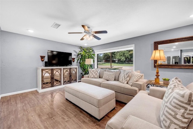 living room featuring hardwood / wood-style floors and ceiling fan