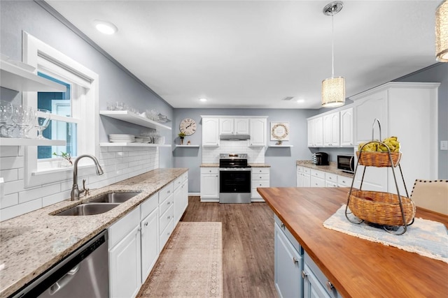 kitchen featuring sink, hanging light fixtures, butcher block countertops, white cabinets, and appliances with stainless steel finishes