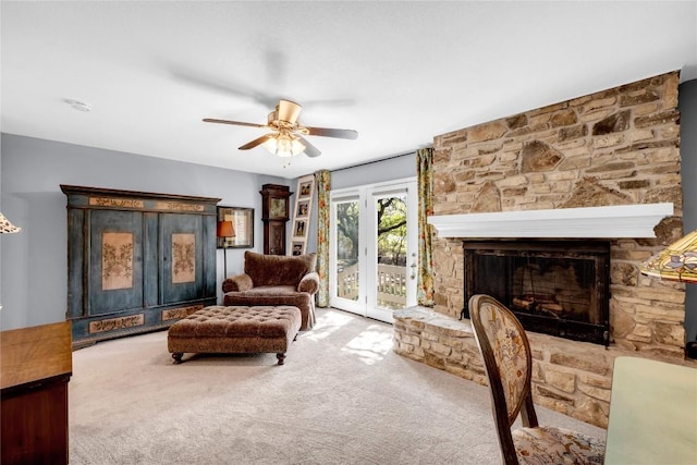 living area with a fireplace, carpet floors, and ceiling fan