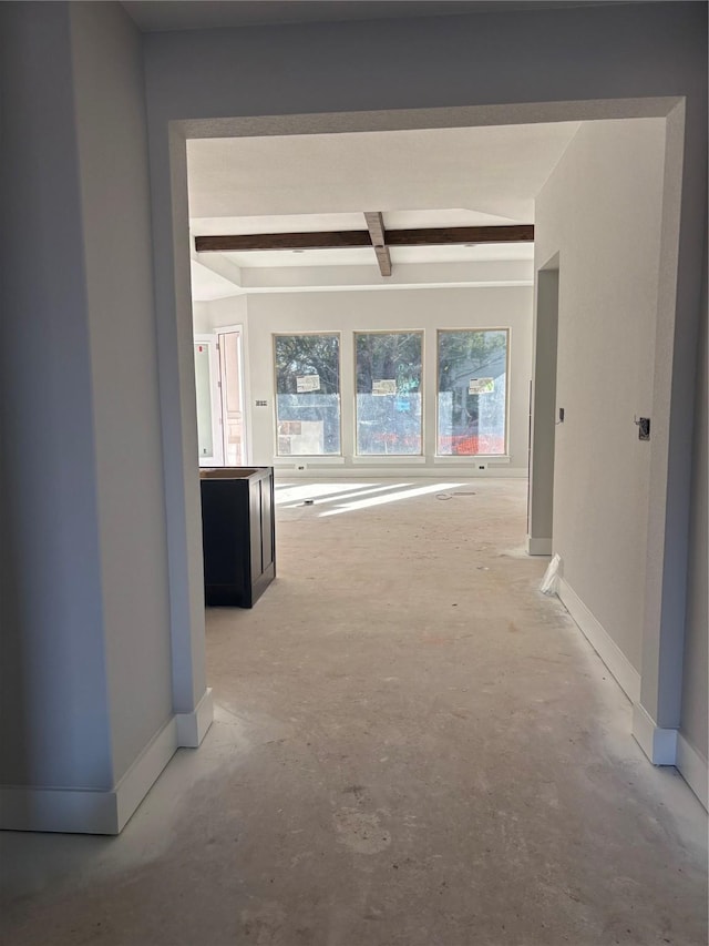 corridor featuring beam ceiling and concrete flooring