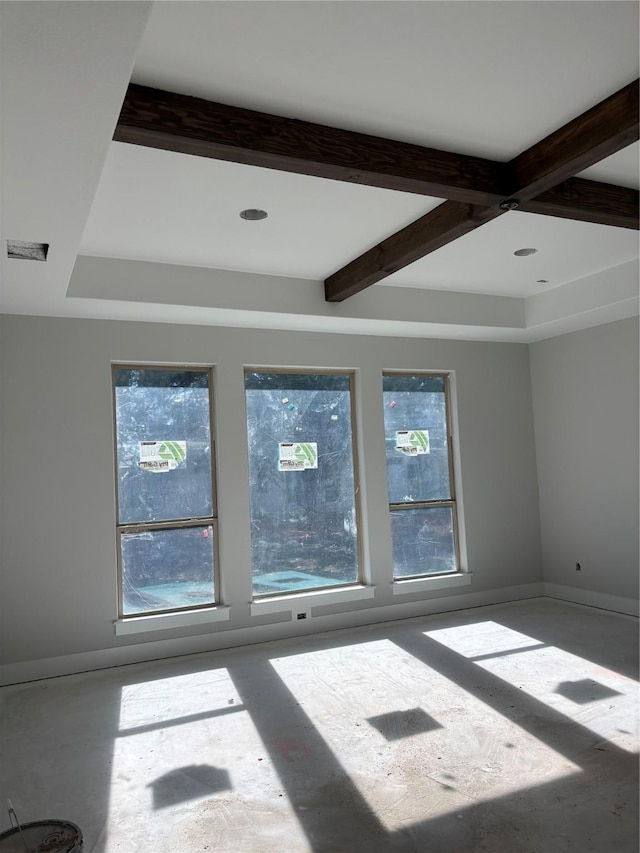 unfurnished room featuring plenty of natural light, beam ceiling, and coffered ceiling