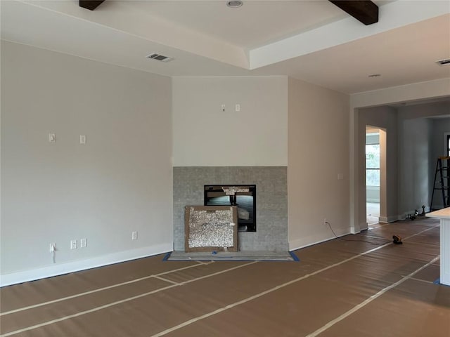 unfurnished living room with visible vents, baseboards, and a multi sided fireplace