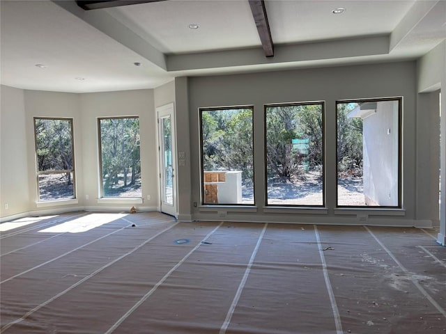 empty room with beam ceiling, recessed lighting, and baseboards