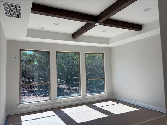 empty room with visible vents, beamed ceiling, and plenty of natural light