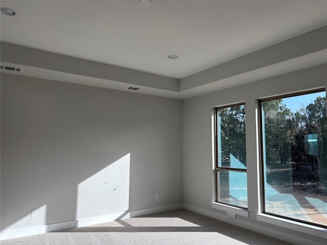 carpeted empty room with visible vents and baseboards