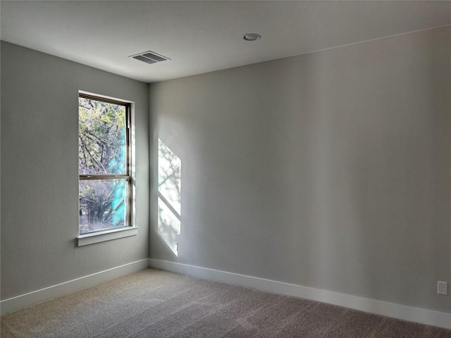 spare room with visible vents, baseboards, and light colored carpet