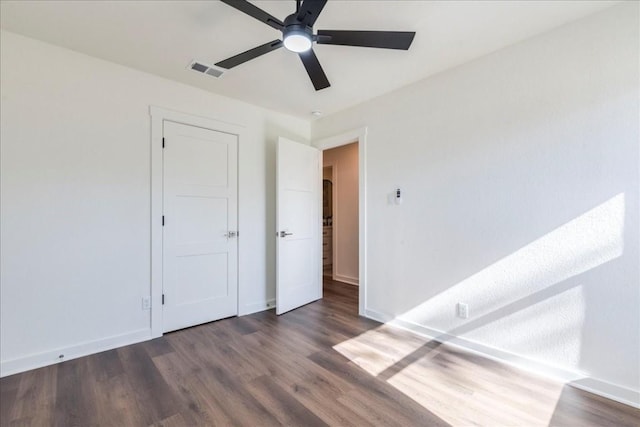 spare room with ceiling fan and dark wood-type flooring