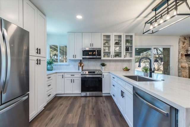 kitchen featuring decorative backsplash, white cabinetry, sink, and appliances with stainless steel finishes