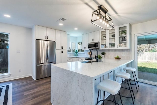 kitchen with pendant lighting, dark wood-type flooring, white cabinets, sink, and appliances with stainless steel finishes