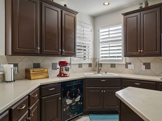 kitchen with tasteful backsplash, sink, dark brown cabinets, and black dishwasher