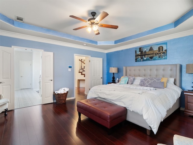 bedroom with ornamental molding, a raised ceiling, ceiling fan, and dark wood-type flooring