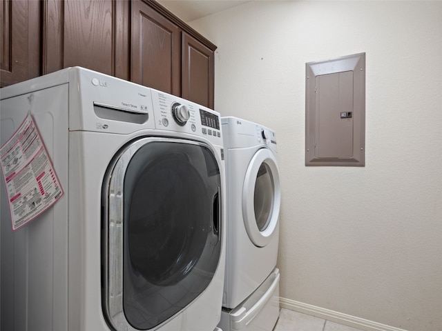 laundry room with electric panel, cabinets, light tile patterned floors, and washer and dryer