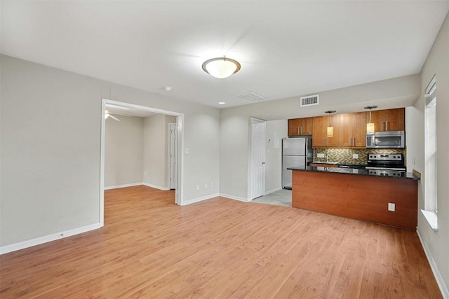 kitchen with backsplash, light hardwood / wood-style flooring, and stainless steel appliances