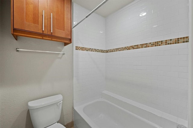 bathroom featuring toilet and tiled shower / bath