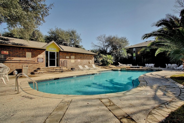 view of swimming pool with a jacuzzi and a patio