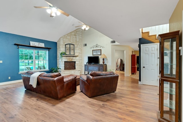 living room with a fireplace, light wood-type flooring, and ceiling fan