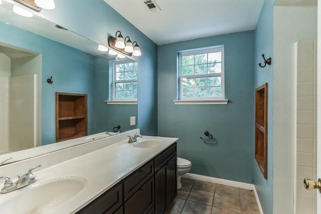 bathroom featuring toilet, vanity, and tile patterned floors