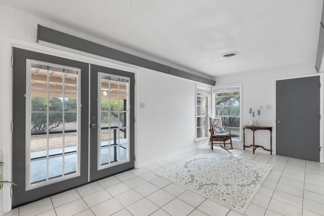 unfurnished room featuring light tile patterned flooring and french doors