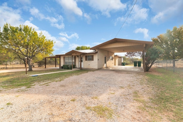 ranch-style house featuring a front lawn and a carport