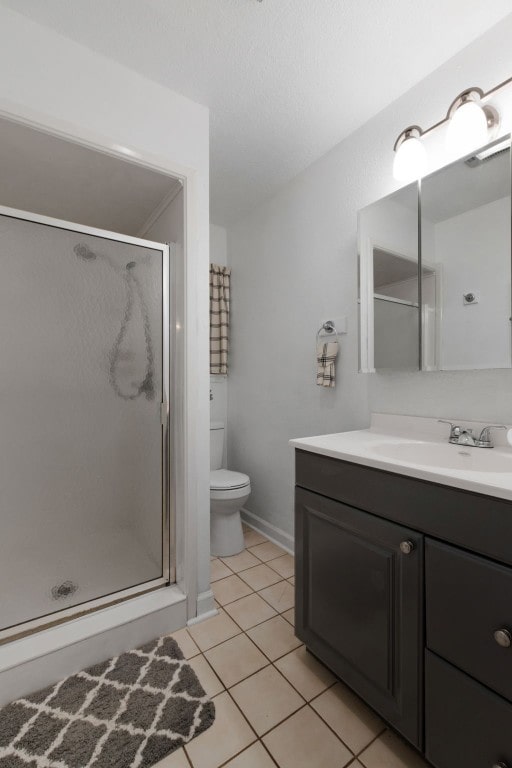 bathroom with tile patterned flooring, vanity, an enclosed shower, and toilet