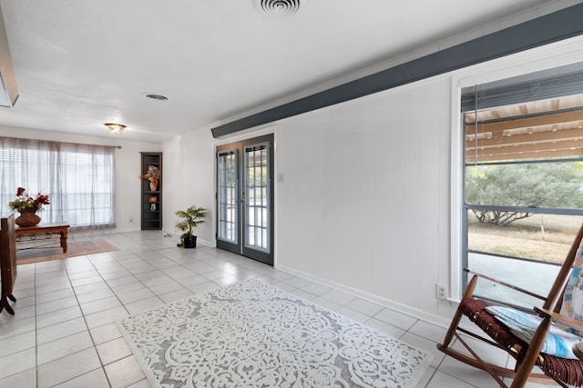 entryway with light tile patterned flooring and french doors