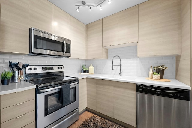 kitchen featuring sink, stainless steel appliances, and light brown cabinetry