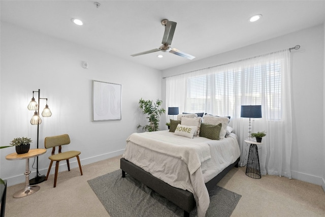 bedroom with multiple windows, light carpet, and ceiling fan