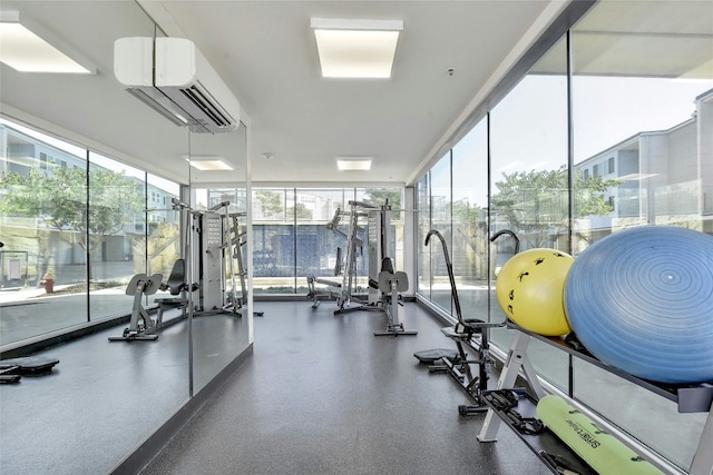 workout area with a wall unit AC and a wall of windows