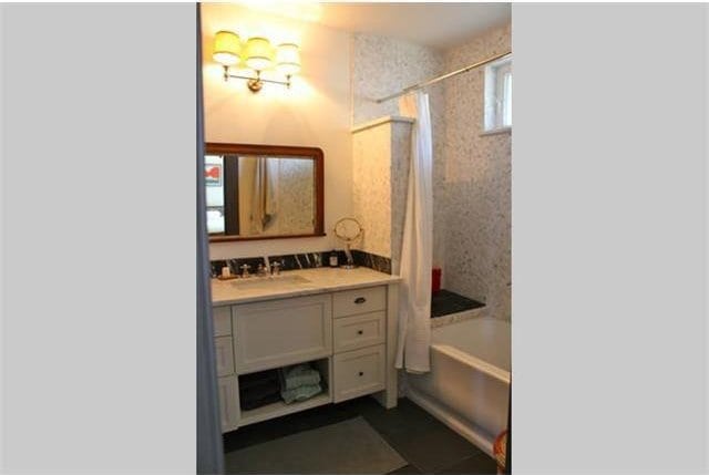 bathroom featuring shower / tub combo and vanity