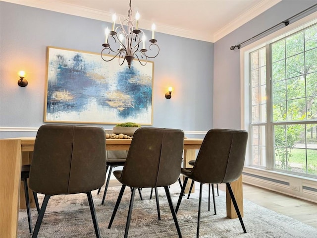 dining space featuring a chandelier, light hardwood / wood-style flooring, and ornamental molding