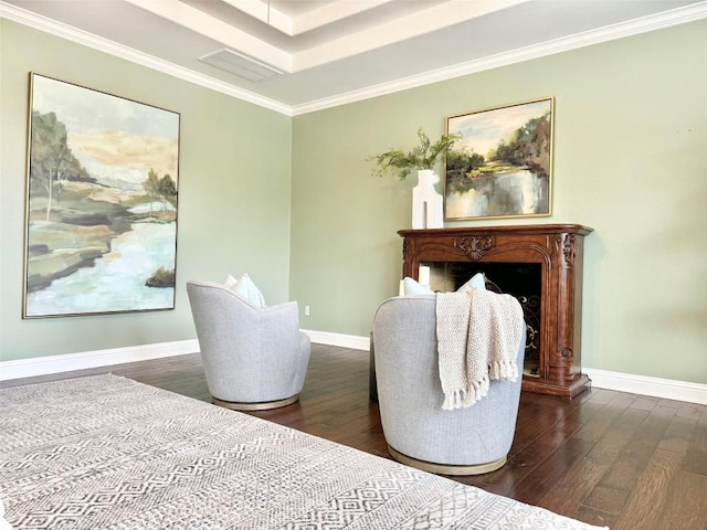 sitting room with dark hardwood / wood-style floors, a raised ceiling, and ornamental molding