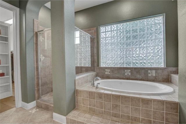 bathroom with separate shower and tub, a wealth of natural light, and tile patterned floors