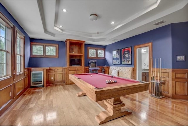 game room featuring light hardwood / wood-style flooring, a raised ceiling, beverage cooler, and pool table