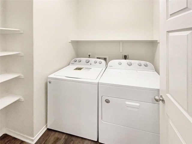 laundry area with washer and dryer and dark wood-type flooring