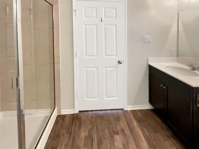 bathroom featuring hardwood / wood-style floors, vanity, and walk in shower