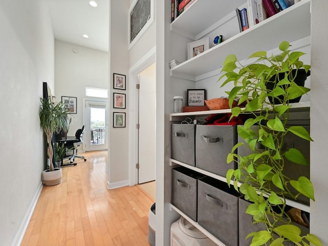 hallway featuring a towering ceiling and hardwood / wood-style flooring