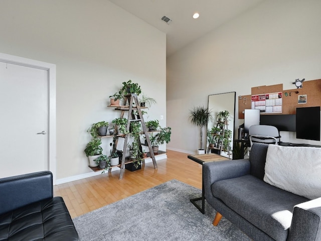 living room with hardwood / wood-style flooring and high vaulted ceiling